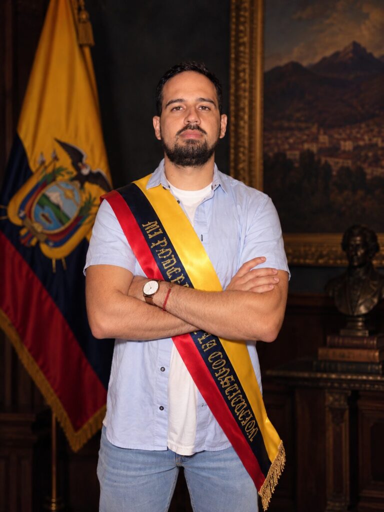 Johnny Manrique con la banda presidencial y la bandera del Ecuador