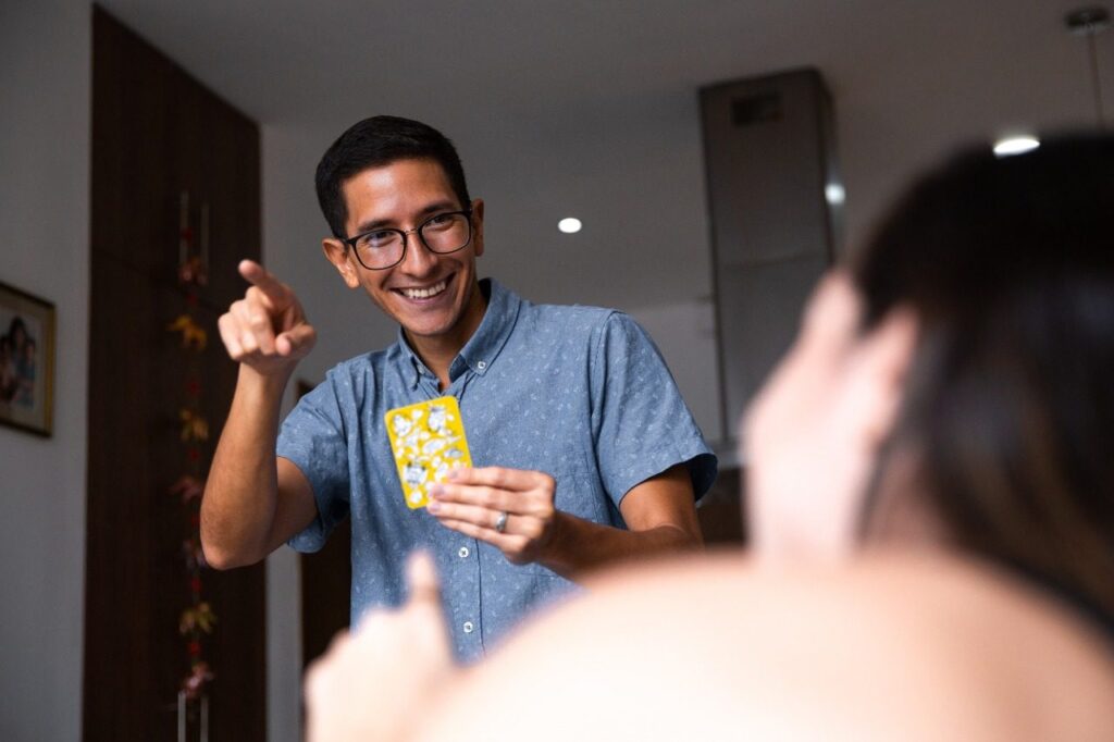 Jugador riendo con una carta en la mano